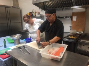 Carme Rodríguez, participant del curs d'auxiliar de cuina del 2016, seguint atentament els trucs que li ensenya Eugeni Piñol, el cuiner de l'Hostal la Creu, on va fer les pràctiques.